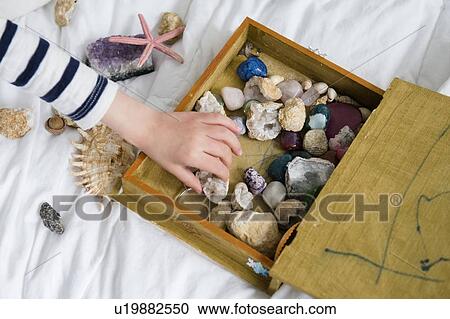 Stock Image - Little boy (4-5) with box full of treasures. Fotosearch