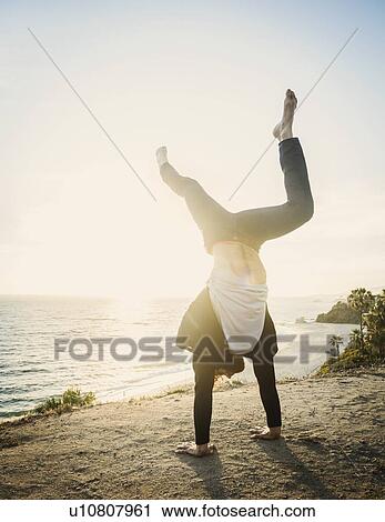 Man doing handstand on beach View Large Photo Image Stock Image - Man doing handstand on beach. Fotosearch