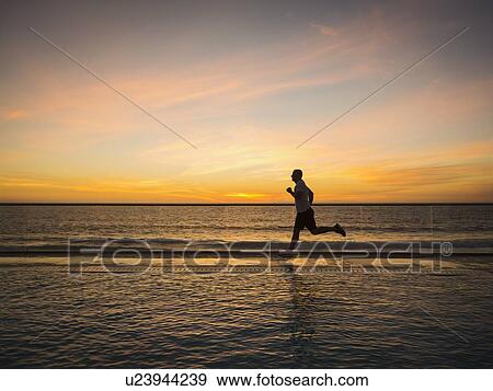 Stock Photo - Man jogging along poolside. Fotosearch