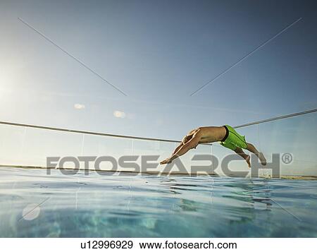 Stock Photo - Man jumping into swimming pool. Fotosearch