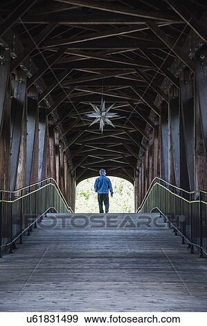 Man on covered bridge View Large Photo Image Stock Photo - Man on covered bridge. Fotosearch