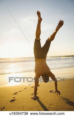 Stock Photo - Man standing on hand. Fotosearch
