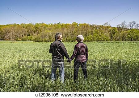 Mature couple holding hands in field View Large Photo Image Stock Photography - Mature couple holding hands in field. Fotosearch