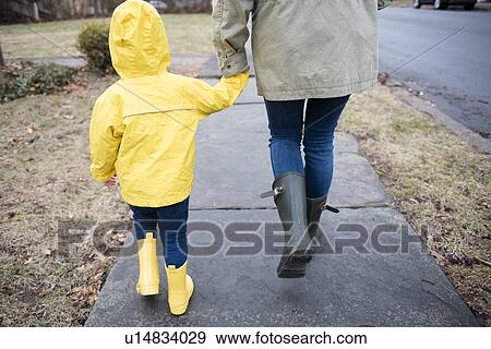 Mother and daughter (2-3) holding hands and walking on rainy day View Large Photo Image Stock Photo - Mother and daughter (2-3) holding hands and walking on rainy day. Fotosearch