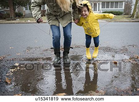 Stock Photo - Mother and daughter (2-3) near puddle. Fotosearch