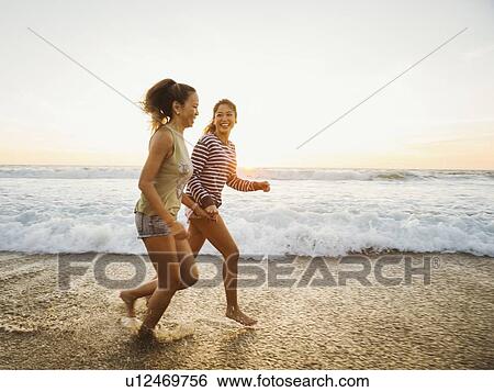 Mother and daughter jogging along beach View Large Photo Image Stock Photograph - Mother and daughter jogging along beach. Fotosearch