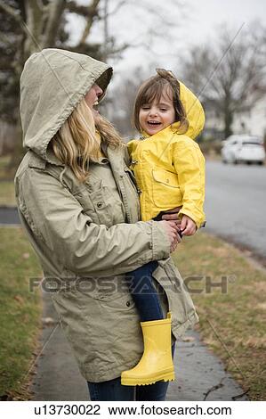 Stock Image - Mother carrying daughter (2-3) outdoors. Fotosearch
