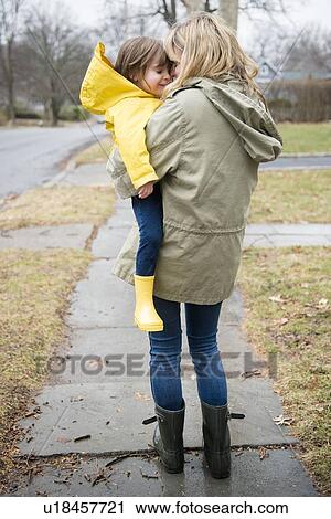 Stock Image - Mother carrying daughter (2-3) outdoors. Fotosearch