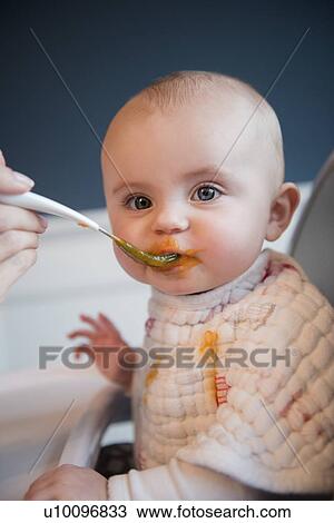 Stock Image - Mother feeding baby (18-23 months). Fotosearch