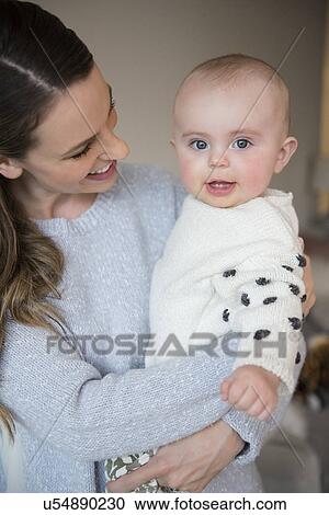 Stock Image - Mother holding baby (18-23 months) in arms. Fotosearch