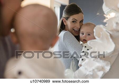Stock Photo - Mother holding baby (18-23 months) in front of mirror. Fotosearch