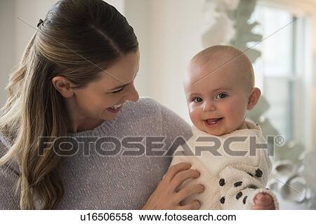 Stock Photo - Mother holding baby (18-23 months) in arms. Fotosearch