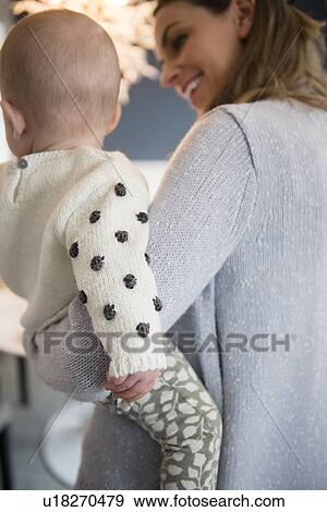 Mother holding baby (18-23 months) in arms View Large Photo Image Stock Photo - Mother holding baby (18-23 months) in arms. Fotosearch