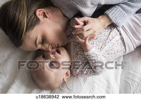 Mother kissing baby girl (18-23 months) with care View Large Photo Image Stock Image - Mother kissing baby girl (18-23 months) with care. Fotosearch