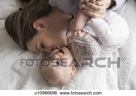 Mother kissing baby girl (18-23 months) with care View Large Photo Image Stock Photograph - Mother kissing baby girl (18-23 months) with care. Fotosearch