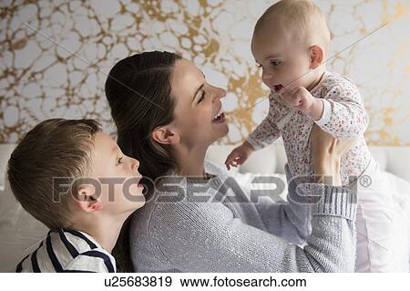 Stock Photo - Mother playing with children (18-23 months, 4-5). Fotosearch