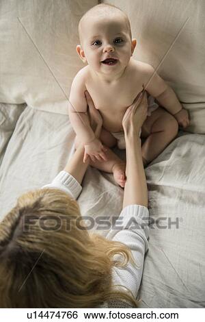 Stock Photograph - Mother with baby girl (12-17 months) in bed. Fotosearch