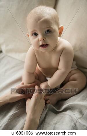 Stock Photography - Mother with baby girl (12-17 months) in bed. Fotosearch