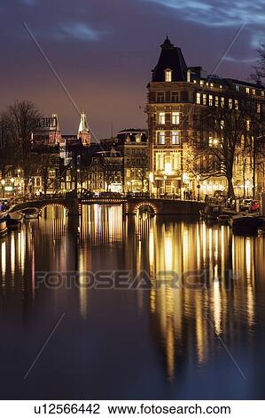 Stock Image - Netherlands, Amsterdam, Bascule bridge over canal at night. Fotosearch