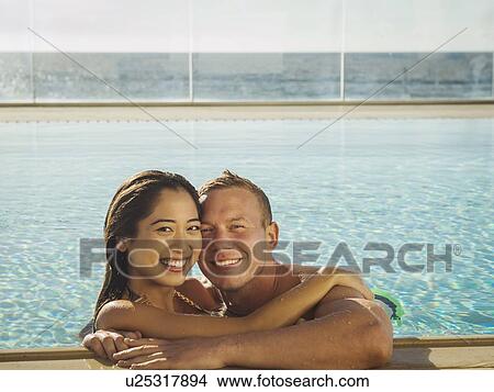 Portrait of couple embracing in swimming pool View Large Photo Image Picture - Portrait of couple embracing in swimming pool. Fotosearch