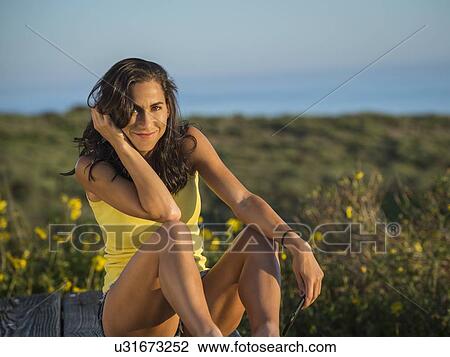Stock Image - Portrait of women sitting among wildflowers. Fotosearch