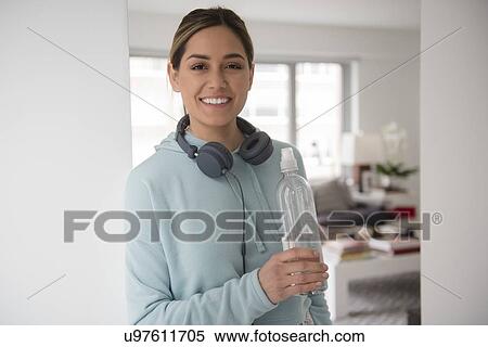 Stock Photography - Portrait of young woman holding water bottle. Fotosearch