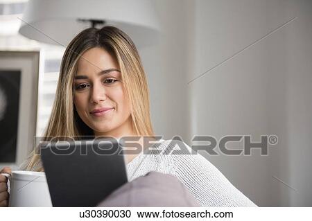 Stock Image - Portrait of young woman using digital tablet. Fotosearch