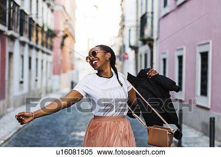 Portugal, Lisbon, Smiling young woman dancing in old town View Large Photo Image Stock Photography - Portugal, Lisbon, Smiling young woman dancing in old town. Fotosearch