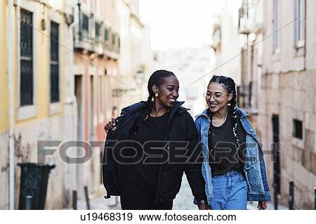 Portugal, Lisbon, Two smiling young women walking outdoors View Large Photo Image Stock Photo - Portugal, Lisbon, Two smiling young women walking outdoors. Fotosearch