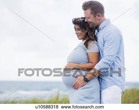 Pregnant couple embracing View Large Photo Image Stock Photo - Pregnant couple embracing. Fotosearch