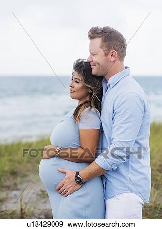 Pregnant couple embracing View Large Photo Image Stock Photo - Pregnant couple embracing. Fotosearch