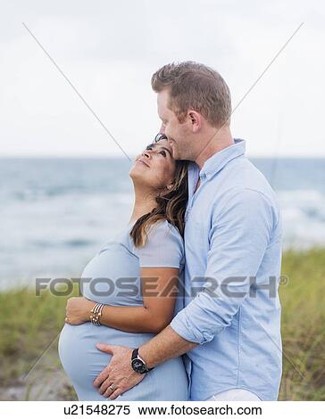 Pregnant couple embracing View Large Photo Image Stock Photography - Pregnant couple embracing. Fotosearch