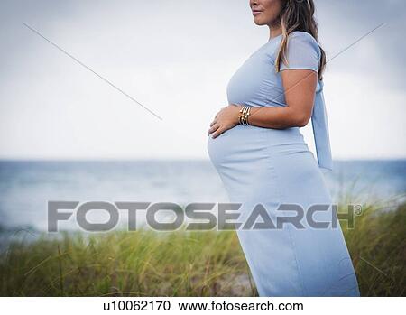Pregnant woman wearing blue dress View Large Photo Image Stock Image - Pregnant woman wearing blue dress. Fotosearch