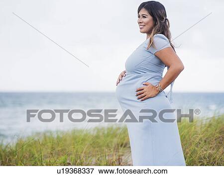 Pregnant woman wearing blue dress View Large Photo Image Stock Photo - Pregnant woman wearing blue dress. Fotosearch