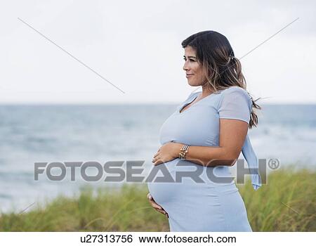 Pregnant woman wearing blue dress View Large Photo Image Stock Photograph - Pregnant woman wearing blue dress. Fotosearch