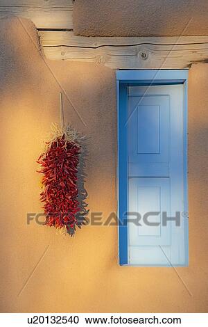 Stock Image - Red chilis on adobe wall. Fotosearch