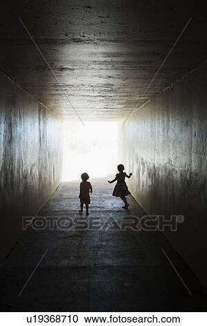 Stock Image - Silhouettes of children in tunnel. Fotosearch