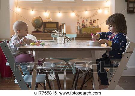 Sisters (12-17 months, 2-3) eating at table View Large Photo Image Stock Photography - Sisters (12-17 months, 2-3) eating at table. Fotosearch