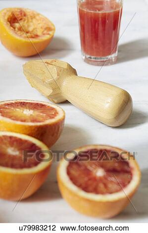 Stock Image - Sliced grapefruit with juicer. Fotosearch
