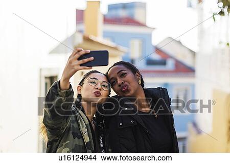Two young women taking selfie outdoors View Large Photo Image Picture - Two young women taking selfie outdoors. Fotosearch