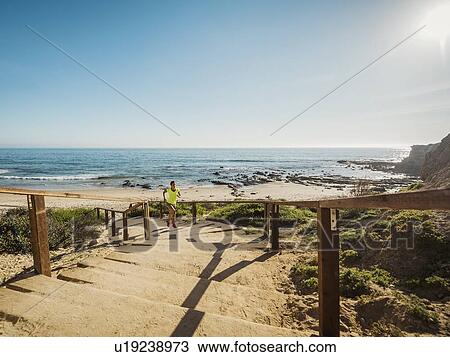 USA, California, Newport Beach, Woman running up stairs View Large Photo Image Stock Image - USA, California, Newport Beach, Woman running up stairs. Fotosearch