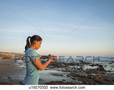 USA, California, Newport Beach, Woman checking smart watch View Large Photo Image Stock Image - USA, California, Newport Beach, Woman checking smart watch. Fotosearch