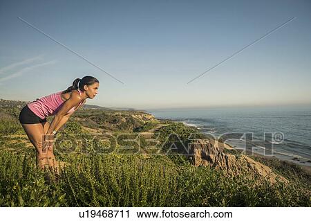 Stock Image - USA, California, Newport Beach, Woman resting and looking at sea. Fotosearch