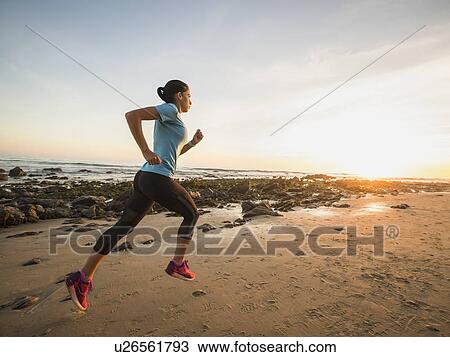 USA, California, Newport Beach, Woman jogging on beach View Large Photo Image Stock Image - USA, California, Newport Beach, Woman jogging on beach. Fotosearch