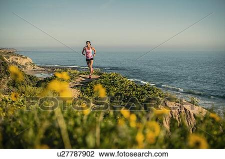 USA, California, Newport Beach, Woman running along cliff View Large Photo Image Stock Image - USA, California, Newport Beach, Woman running along cliff. Fotosearch