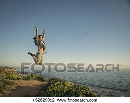 USA, California, Newport Beach, Woman jumping against clear sky View Large Photo Image Stock Image - USA, California, Newport Beach, Woman jumping against clear sky. Fotosearch