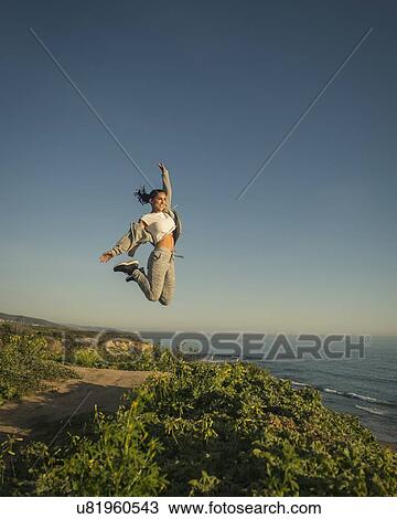 USA, California, Newport Beach, Woman jumping against clear sky View Large Photo Image Stock Image - USA, California, Newport Beach, Woman jumping against clear sky. Fotosearch
