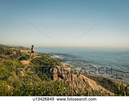 USA, California, Newport Beach, Woman running along cliff View Large Photo Image Stock Photo - USA, California, Newport Beach, Woman running along cliff. Fotosearch