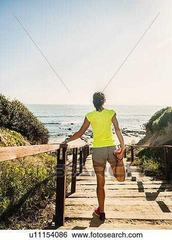 USA, California, Newport Beach, Woman stretching on beach View Large Photo Image Stock Photograph - USA, California, Newport Beach, Woman stretching on beach. Fotosearch
