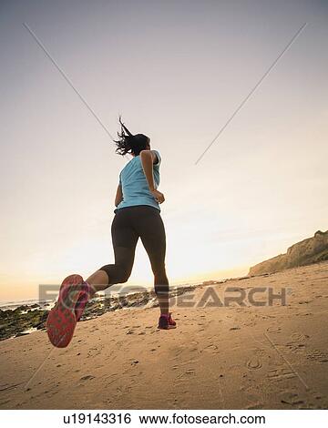 USA, California, Newport Beach, Woman jogging on beach View Large Photo Image Stock Photograph - USA, California, Newport Beach, Woman jogging on beach. Fotosearch